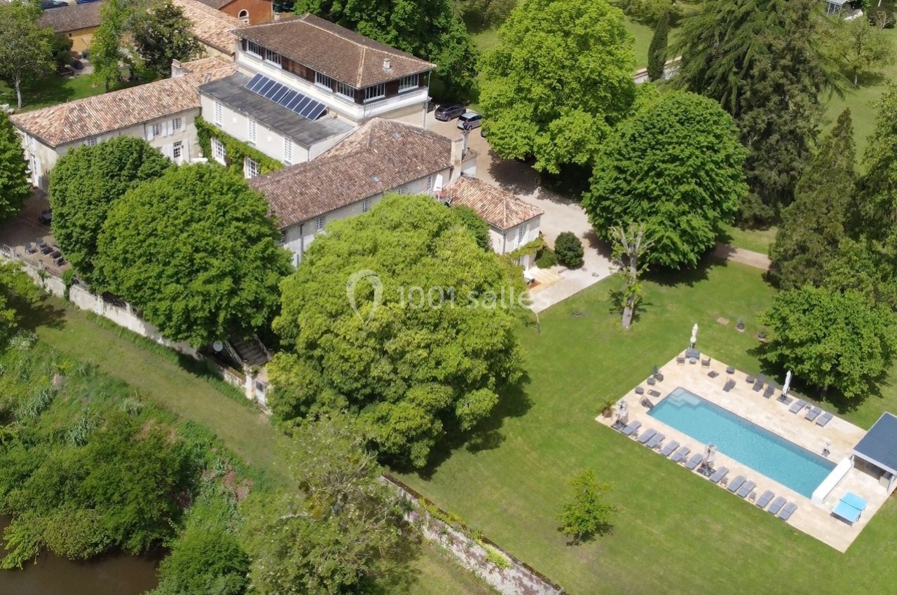 Vue aérienne d'une grande propriété avec piscine, entourée de jardins verdoyants et d'arbres matures.
