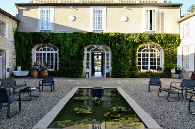Salle de restaurant lumineuse avec tables en bois, chaises blanches, sol à carreaux et décoration élégante.
