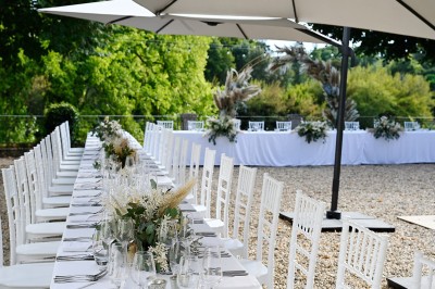 Salle de restaurant lumineuse avec tables en bois, chaises blanches, sol à carreaux et décoration élégante.