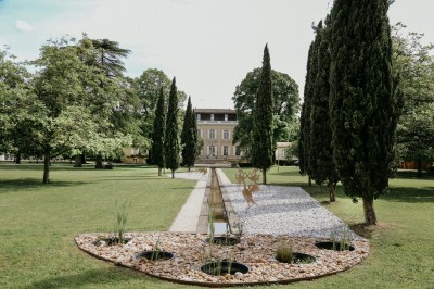 Salle de restaurant lumineuse avec tables en bois, chaises blanches, sol à carreaux et décoration élégante.