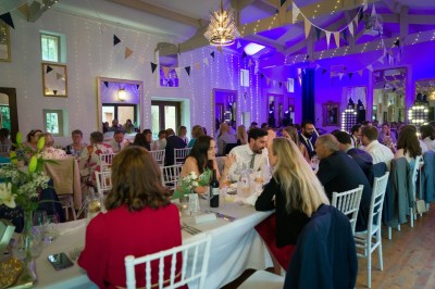 Salle de restaurant lumineuse avec tables en bois, chaises blanches, sol à carreaux et décoration élégante.