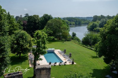 Salle de restaurant lumineuse avec tables en bois, chaises blanches, sol à carreaux et décoration élégante.