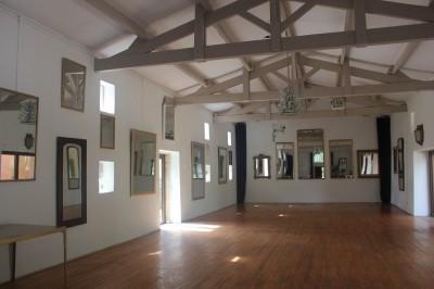 Salle de restaurant lumineuse avec tables en bois, chaises blanches, sol à carreaux et décoration élégante.