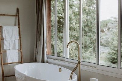 Salle de restaurant lumineuse avec tables en bois, chaises blanches, sol à carreaux et décoration élégante.