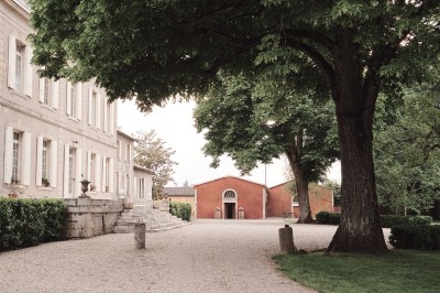 Salle de restaurant lumineuse avec tables en bois, chaises blanches, sol à carreaux et décoration élégante.