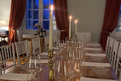 Salle de restaurant lumineuse avec tables en bois, chaises blanches, sol à carreaux et décoration élégante.