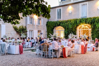 Salle de restaurant lumineuse avec tables en bois, chaises blanches, sol à carreaux et décoration élégante.