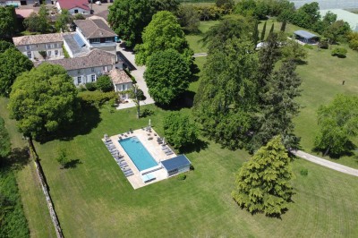 Salle de restaurant lumineuse avec tables en bois, chaises blanches, sol à carreaux et décoration élégante.