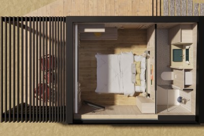 Vue aérienne d'une petite maison avec terrasse en bois, salon, chambre, salle de bain et environnement naturel autour.