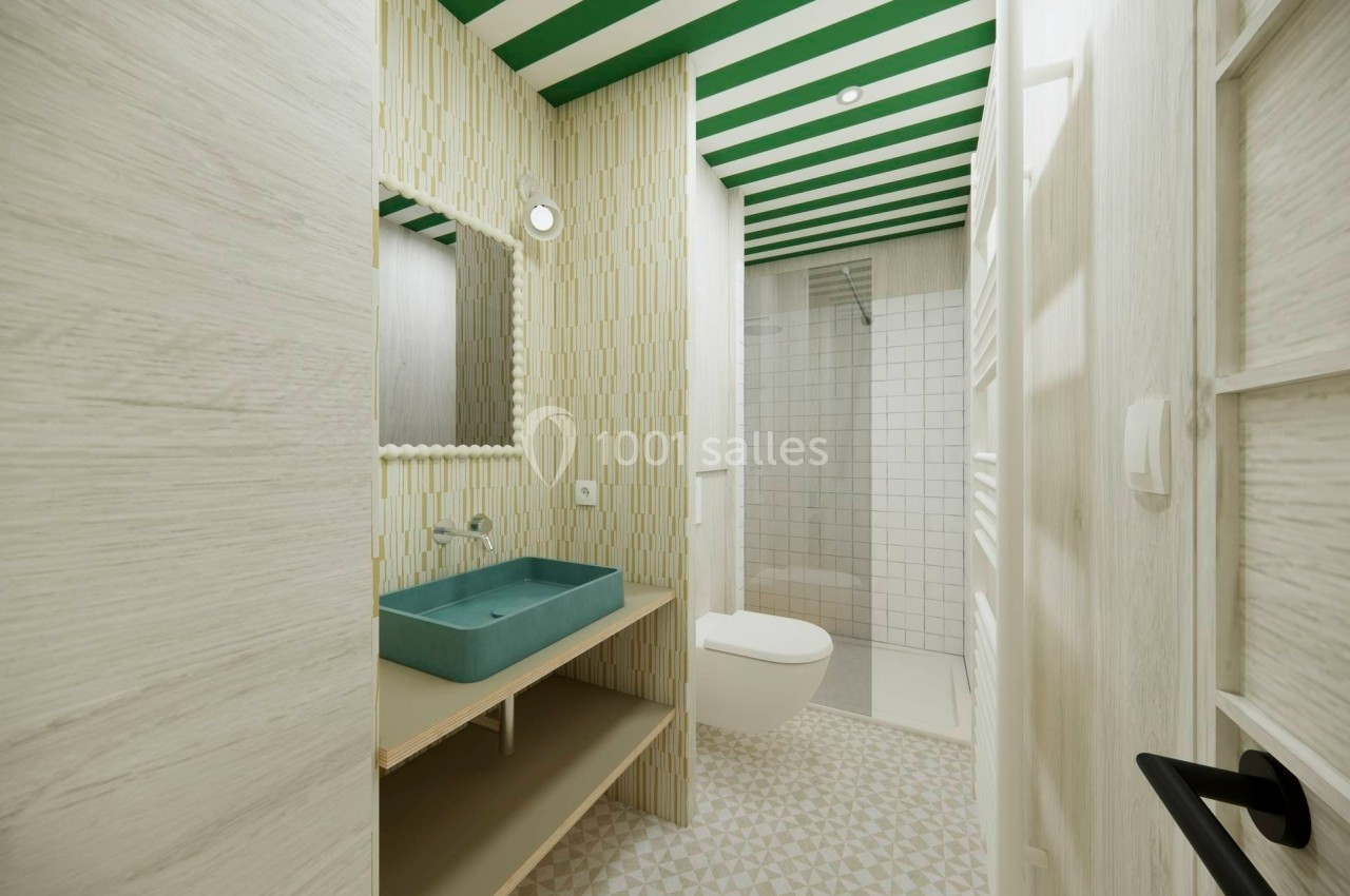 Salle de bain moderne avec lavabo vert, miroir, toilettes suspendues et douche à l'italienne, décorée de tons clairs et…