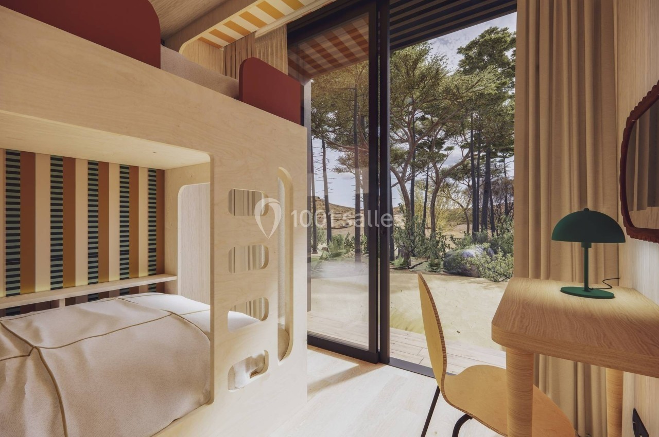 Chambre lumineuse avec lits superposés en bois, bureau et grande baie vitrée donnant sur un paysage arboré.