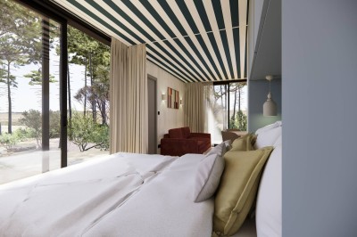 Vue aérienne d'une petite maison avec terrasse en bois, salon, chambre, salle de bain et environnement naturel autour.