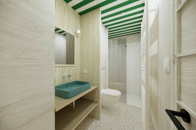 Vue aérienne d'une petite maison moderne avec une chambre, une salle de bain, un salon et une terrasse en bois.