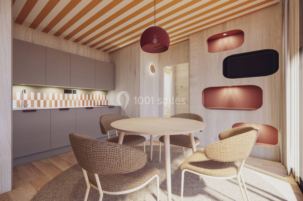 Cuisine moderne avec table ronde, chaises en rotin, éclairage suspendu et décoration murale aux tons chauds.