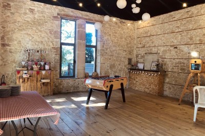 Allée bordée de grands arbres et de feuilles tombées, longeant une balustrade en pierre au coucher du soleil.