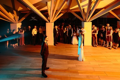 Allée bordée de grands arbres et de feuilles tombées, longeant une balustrade en pierre au coucher du soleil.