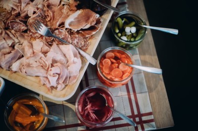 Chambre d'hôtel moderne avec lit double, décor en bois, salle de bain ouverte et vue sur l'extérieur par une baie vitrée.