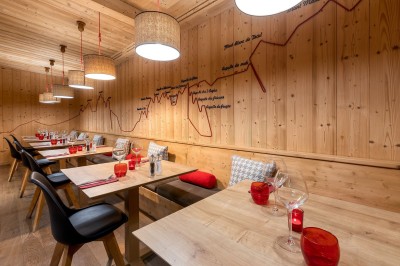 Chambre d'hôtel moderne avec lit double, décor en bois, salle de bain ouverte et vue sur l'extérieur par une baie vitrée.