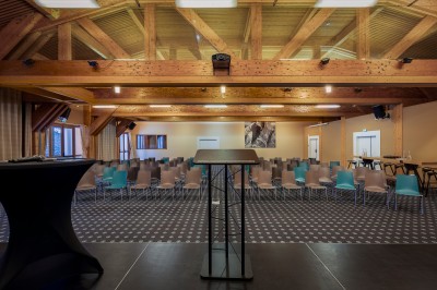 Chambre d'hôtel moderne avec lit double, décor en bois, salle de bain ouverte et vue sur l'extérieur par une baie vitrée.