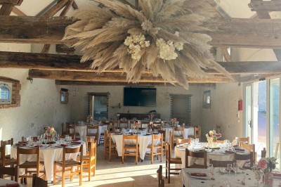 Bâtiment en pierre éclairé par des lumières extérieures, dans une cour sombre au crépuscule.