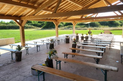 Bâtiment en pierre éclairé par des lumières extérieures, dans une cour sombre au crépuscule.