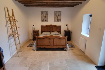 Bâtiment en pierre éclairé par des lumières extérieures, dans une cour sombre au crépuscule.