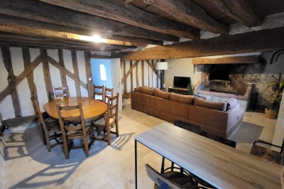 Bâtiment en pierre éclairé par des lumières extérieures, dans une cour sombre au crépuscule.