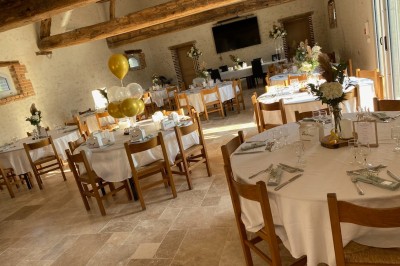 Bâtiment en pierre éclairé par des lumières extérieures, dans une cour sombre au crépuscule.