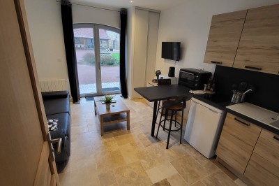 Bâtiment en pierre éclairé par des lumières extérieures, dans une cour sombre au crépuscule.