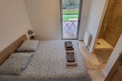 Bâtiment en pierre éclairé par des lumières extérieures, dans une cour sombre au crépuscule.