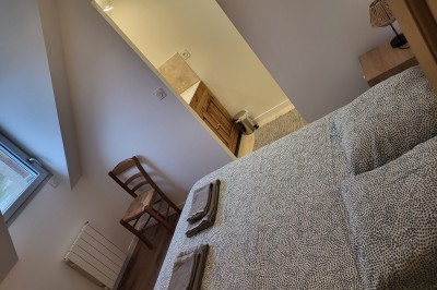 Bâtiment en pierre éclairé par des lumières extérieures, dans une cour sombre au crépuscule.