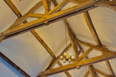 Bâtiment en pierre éclairé par des lumières extérieures, dans une cour sombre au crépuscule.