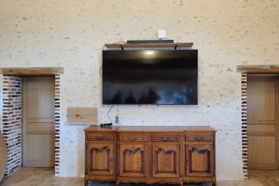 Bâtiment en pierre éclairé par des lumières extérieures, dans une cour sombre au crépuscule.