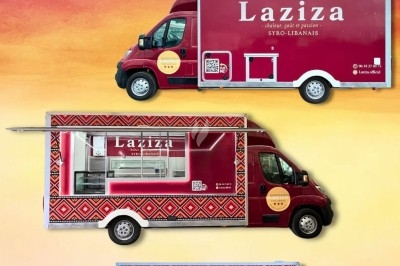 Camion de restauration rapide rouge avec motifs orientaux, vitrine latérale ouverte et logo ’Laziza’.