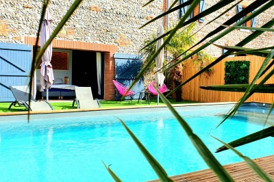 Table décorée avec des pampas et des nappes beige, installée dans un jardin avec des plantes tropicales en arrière-plan.