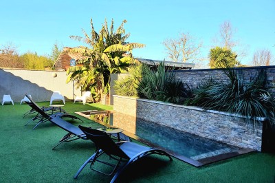 Table décorée avec des pampas et des nappes beige, installée dans un jardin avec des plantes tropicales en arrière-plan.