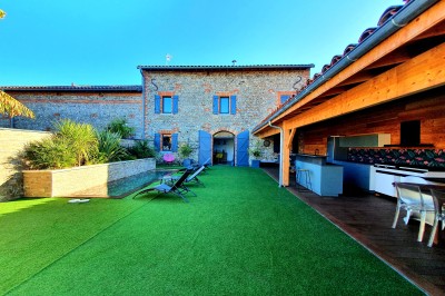 Table décorée avec des pampas et des nappes beige, installée dans un jardin avec des plantes tropicales en arrière-plan.