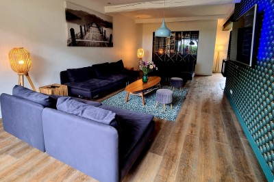 Table décorée avec des pampas et des nappes beige, installée dans un jardin avec des plantes tropicales en arrière-plan.