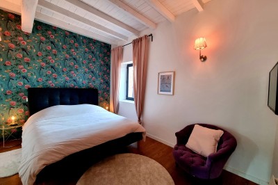 Table décorée avec des pampas et des nappes beige, installée dans un jardin avec des plantes tropicales en arrière-plan.