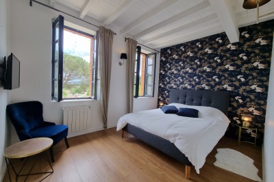 Table décorée avec des pampas et des nappes beige, installée dans un jardin avec des plantes tropicales en arrière-plan.