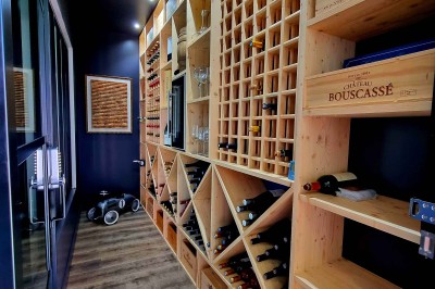 Table décorée avec des pampas et des nappes beige, installée dans un jardin avec des plantes tropicales en arrière-plan.