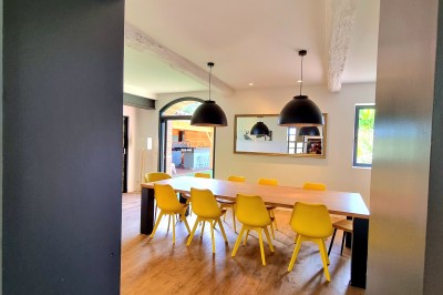 Table décorée avec des pampas et des nappes beige, installée dans un jardin avec des plantes tropicales en arrière-plan.