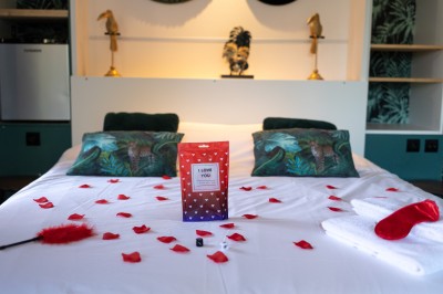 Table décorée avec des pampas et des nappes beige, installée dans un jardin avec des plantes tropicales en arrière-plan.