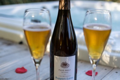 Table décorée avec des pampas et des nappes beige, installée dans un jardin avec des plantes tropicales en arrière-plan.