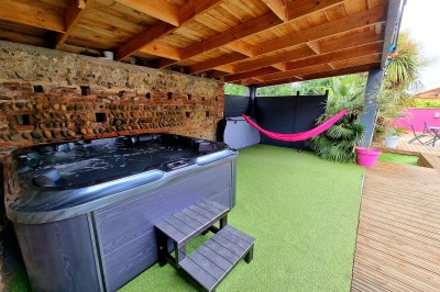 Table décorée avec des pampas et des nappes beige, installée dans un jardin avec des plantes tropicales en arrière-plan.