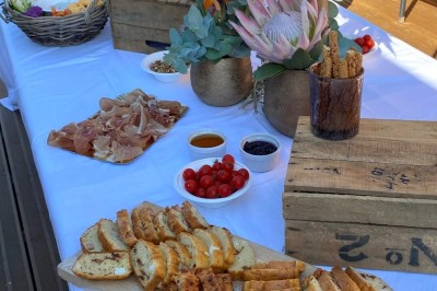 Table décorée avec des pampas et des nappes beige, installée dans un jardin avec des plantes tropicales en arrière-plan.