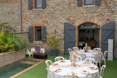 Table décorée avec des pampas et des nappes beige, installée dans un jardin avec des plantes tropicales en arrière-plan.