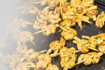 Table décorée avec des pampas et des nappes beige, installée dans un jardin avec des plantes tropicales en arrière-plan.