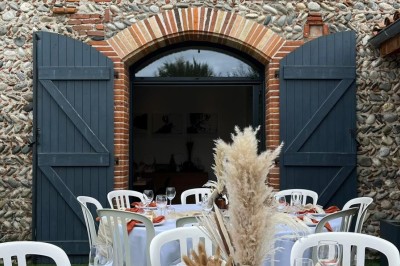 Table décorée avec des pampas et des nappes beige, installée dans un jardin avec des plantes tropicales en arrière-plan.