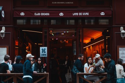 Miniature Location salle Paris 9 (Paris) - Club Cochon l'Auberge #33 Deux jeunes femmes souriantes tenant des verres, entourées de personnes dans une ambiance festive et lumineuse.